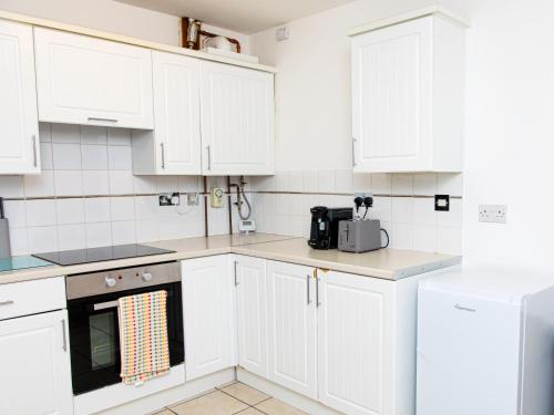 a white kitchen with white cabinets and appliances at Manchester 2Bedroom Near Etihad Stadium & Coop Live Arena in Manchester