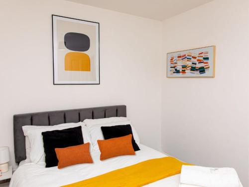 a bedroom with a bed with orange and yellow pillows at Manchester 2Bedroom Near Etihad Stadium & Coop Live Arena in Manchester