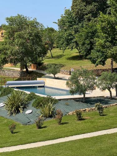 - une piscine dans un parc avec des arbres et de la pelouse dans l'établissement Domaine de la Source, à Castels