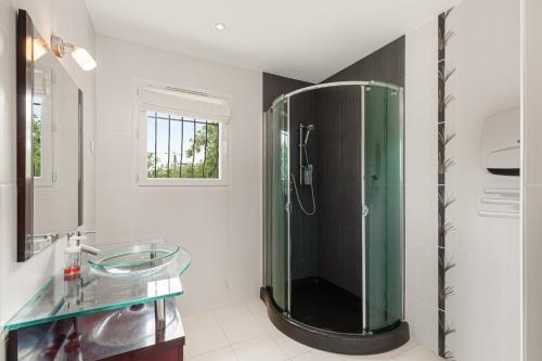 une salle de bain avec une douche en verre et un lavabo dans l'établissement Maison VALFLO, à Saint-Cézaire-sur-Siagne