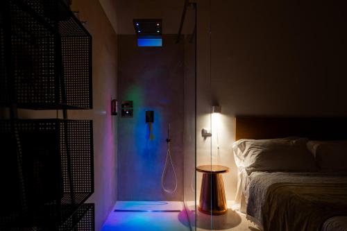 a room with a bedroom with a bed and a lamp at Donna Domenica Boutique Suites in Polignano a Mare