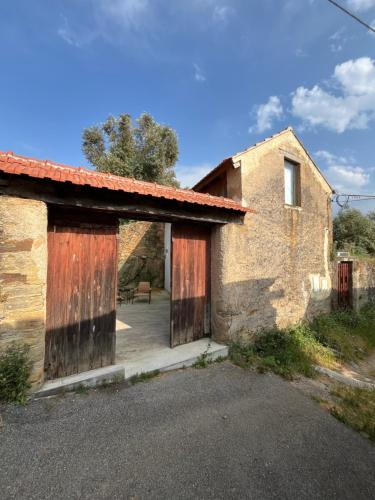 an old brick building with two wooden doors at Casa Abílio - country house in Alvoeira