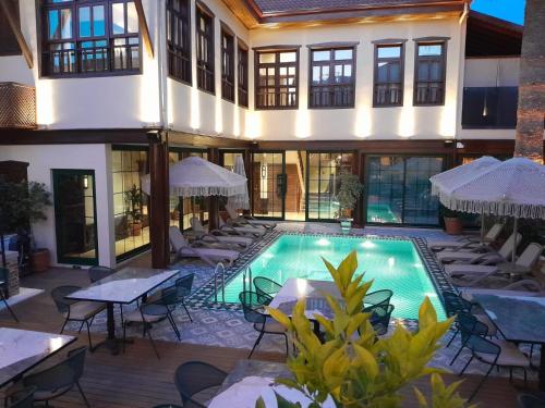 ein Hallenbad mit Tischen und Stühlen neben einem Gebäude in der Unterkunft Belmondo Suites Hare Old Town Antalya in Antalya