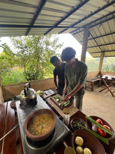 two men are preparing food on a table at Royal Mountain Edge ,Knuckles in Rangala