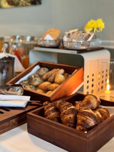 two trays of bread and other baked goods on a counter at Palazzo Tiglio - A Small Luxury Hotels of the World in San Pancrazio