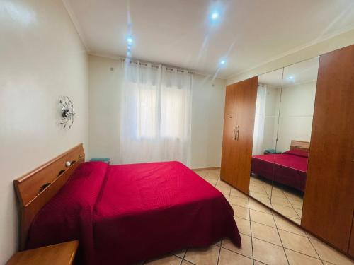 a bedroom with a red bed and a mirror at Alloggio Turistico Pamela Leporace in Fiumicino