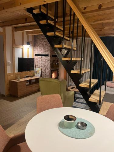 a living room with a table and a staircase at Mila house Tara in Bajina Bašta