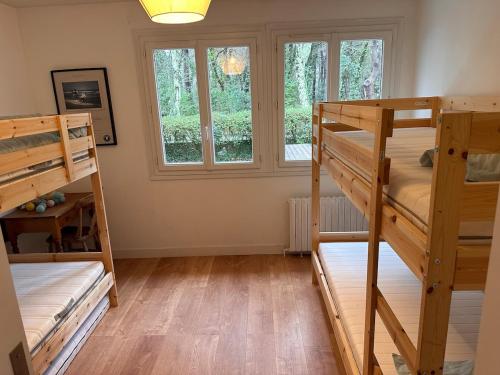 une chambre avec deux lits superposés et une fenêtre dans l'établissement Villa & heated pool Arcachon Pyla Moulleau, à La Teste-de-Buch