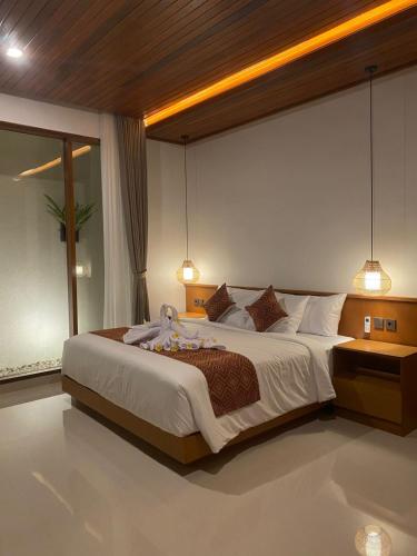 a bedroom with a large bed with two lights at Dream House Ubud in Ubud