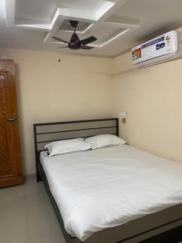a bedroom with a bed with a ceiling fan at Alif Serviced (Hotel) Apartments in Tambaram