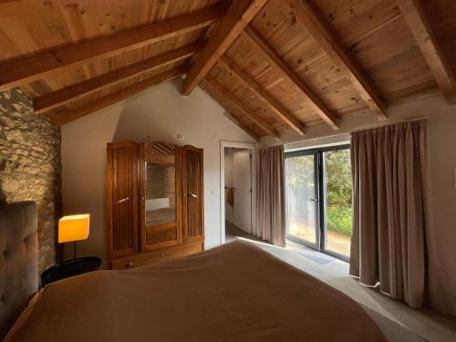 a bedroom with a bed and a large window at Casa Abílio - country house in Alvoeira