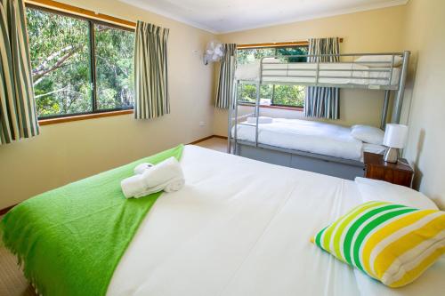 a bedroom with two bunk beds with towels at Granite Belt Retreat and Brewery in Stanthorpe