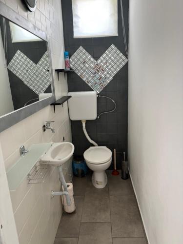 a small bathroom with a toilet and a sink at Sunset Beach House in Fonyód