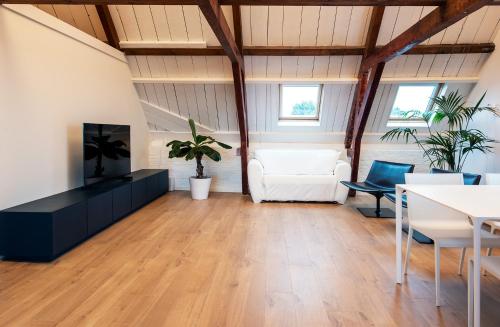 a living room with a white couch and a tv at B&B 'de Wenteltrap' in Makkum