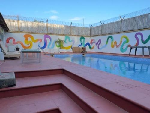 a swimming pool with a mural of birds on the wall at SmartFix Luxury Properties in Lagos