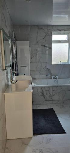 a bathroom with a sink and a toilet and a tub at Family house in Lemington