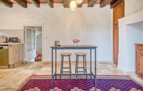 une cuisine avec une table et deux tabourets dans l'établissement Charmante Maison À La Campagne, à Jaure