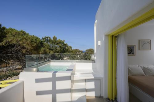 a white house with a swimming pool on a balcony at New Earth in Kamari