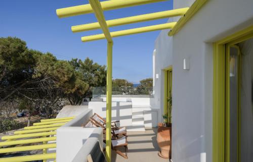 a yellow rain gutter on a white house with stairs at New Earth in Kamari