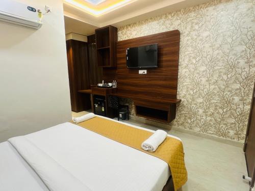 a hotel room with a bed and a flat screen tv at hotel deep palace in Varanasi