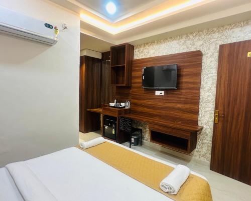 a hotel room with a bed and a flat screen tv at hotel deep palace in Varanasi