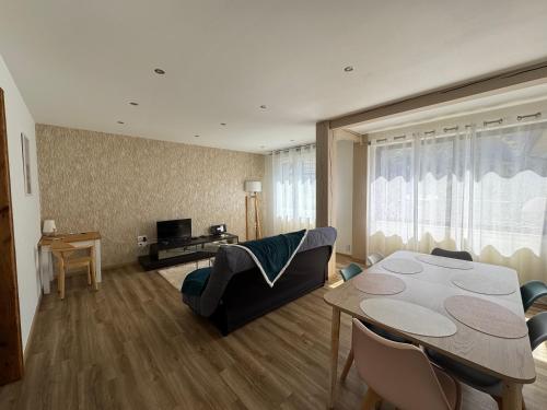 un salon avec une table et un canapé dans l'établissement Appartement dans une cité de caractère, à Mouthier-Haute-Pierre