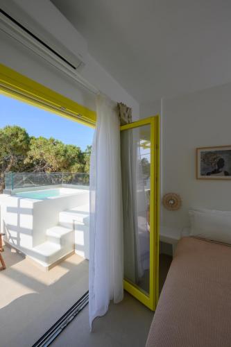 a bedroom with a large window with a view of a pool at New Earth in Kamari