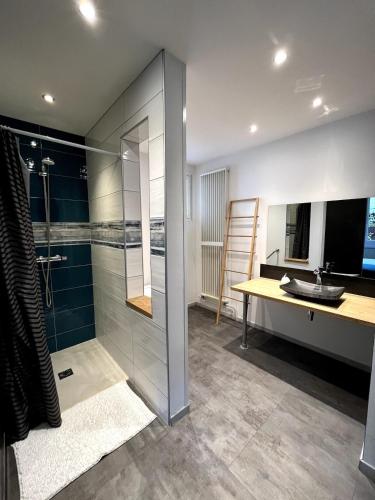 une salle de bain avec une douche, un lavabo et un miroir dans l'établissement Appartement dans une cité de caractère, à Mouthier-Haute-Pierre