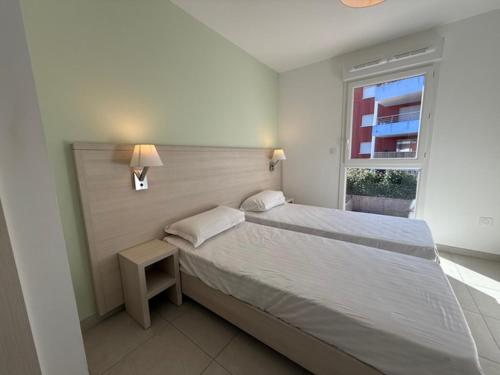 une chambre avec un grand lit et une fenêtre dans l'établissement maz poseidon 74, à Bormes-les-Mimosas