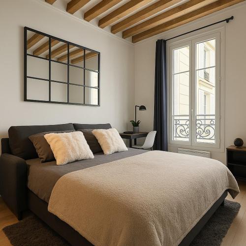 une chambre avec un grand lit et une fenêtre dans l'établissement Havre de paix aux Champs-Elysées, à Paris