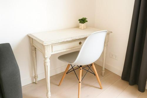 - un bureau blanc avec une chaise blanche dans la chambre dans l'établissement Havre de paix aux Champs-Elysées, à Paris