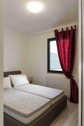 a bedroom with a bed with a red curtain at rapisardi 8 in Riccione
