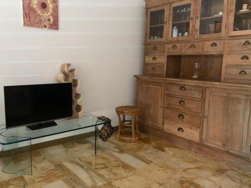 a living room with a tv and a glass table at The Riviera Apartment in Lavagna