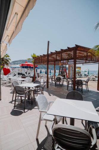 an outdoor patio with tables and chairs and the beach at Xperia Saray Beach Hotel in Alanya