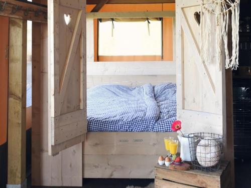 1 cama en una casa de madera con ventana en Beach Lodge Callantsoog near the Sea, en Callantsoog