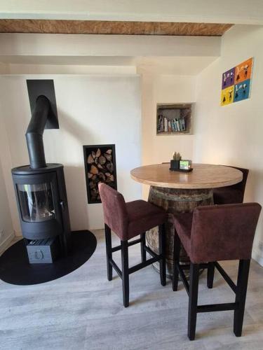 - un salon avec une table et un poêle à bois dans l'établissement Kervihan village house, à Saint-Pierre-Quiberon
