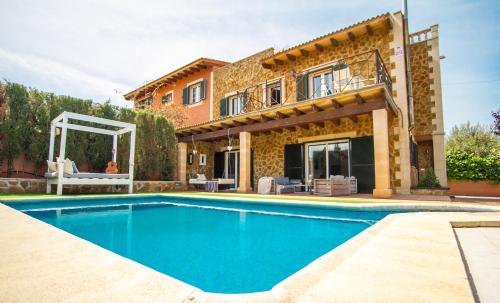 a villa with a swimming pool in front of a house at Villa Petit Lujo in Badia Gran