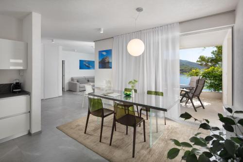 a kitchen and dining room with a glass table and chairs at Duka & Piko apartmani in Otok Lastovo