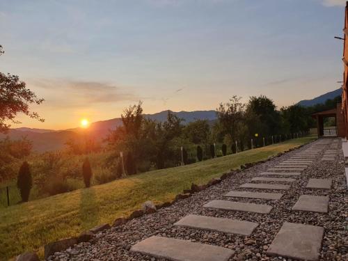 a stone path with the sunset in the background at LiAn House in Corbeni