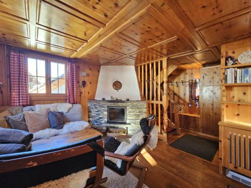 a living room with a couch and a fireplace at Chalet Le Camée in Saas-Fee