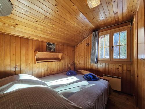 a bedroom with a bed in a wooden cabin at Chalet Le Camée in Saas-Fee