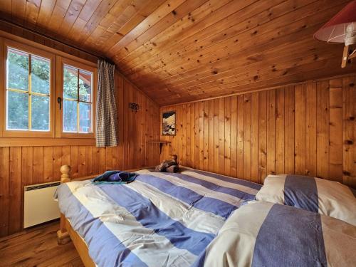 a bedroom with a bed in a wooden room at Chalet Le Camée in Saas-Fee