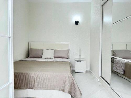 Un dormitorio pequeño con una cama y un espejo. en Квартира Новомоссковская, en Salor Bekati