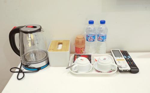 a counter with a blender and bottles of water at Mia Noi Bai Airport Hotel in Noi Bai