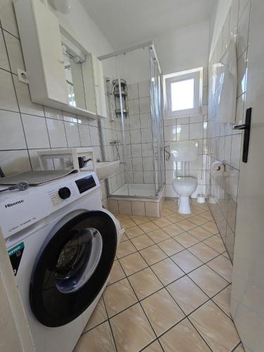 a bathroom with a washing machine and a toilet at Mandica in Seline