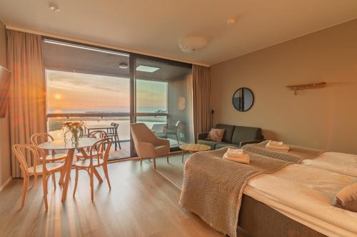 a hotel room with a bed and a table and chairs at Marina Chalets Studios by Hiekka Booking - sisältää liinavaatteet ja loppusiivouksen in Kalajoki