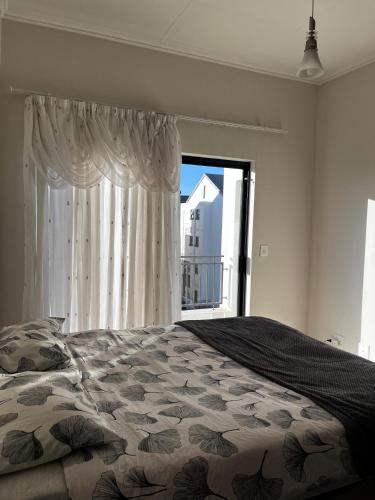 a bedroom with a bed and a large window at G Hill BnB in Edendale