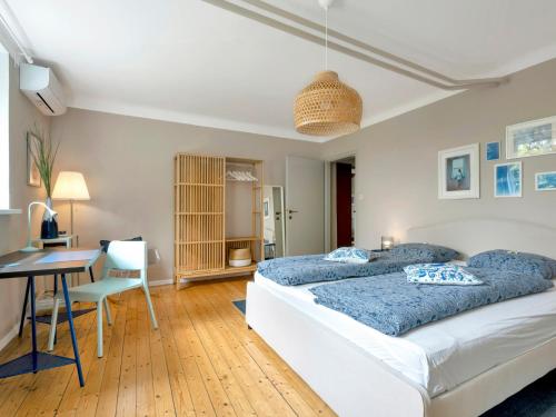 sypialnia z 2 łóżkami, biurkiem i stołem w obiekcie Gemütliche Ferienwohnung mit Terrasse und Seeblick w mieście Velden am Wörthersee