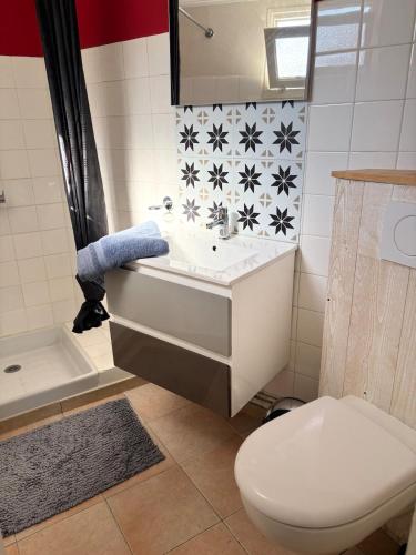 une salle de bain avec un lavabo blanc et des toilettes dans l'établissement Chez Manon & David, à La Flotte