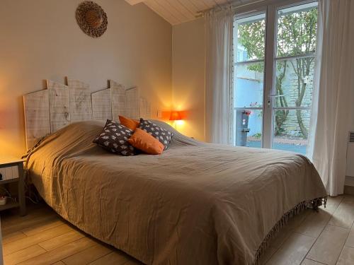 un lit dans une chambre avec une grande fenêtre dans l'établissement Chez Manon & David, à La Flotte
